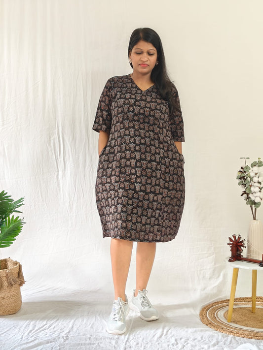 Front-facing model wearing a black Ajrakh block print shift dress with pockets, styled with casual shoes.