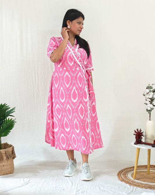 Front-facing model wearing a Pink Ikat cotton dress styled casually with white sneakers and silver jewellery.
