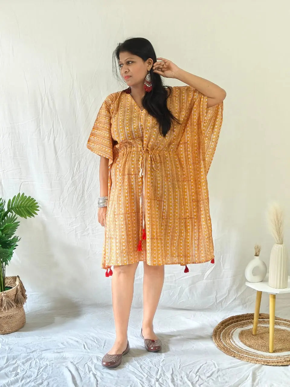 Model in orange Sanganeri kaftan with oxidised earrings, bangles, and juttis for a festive touch.