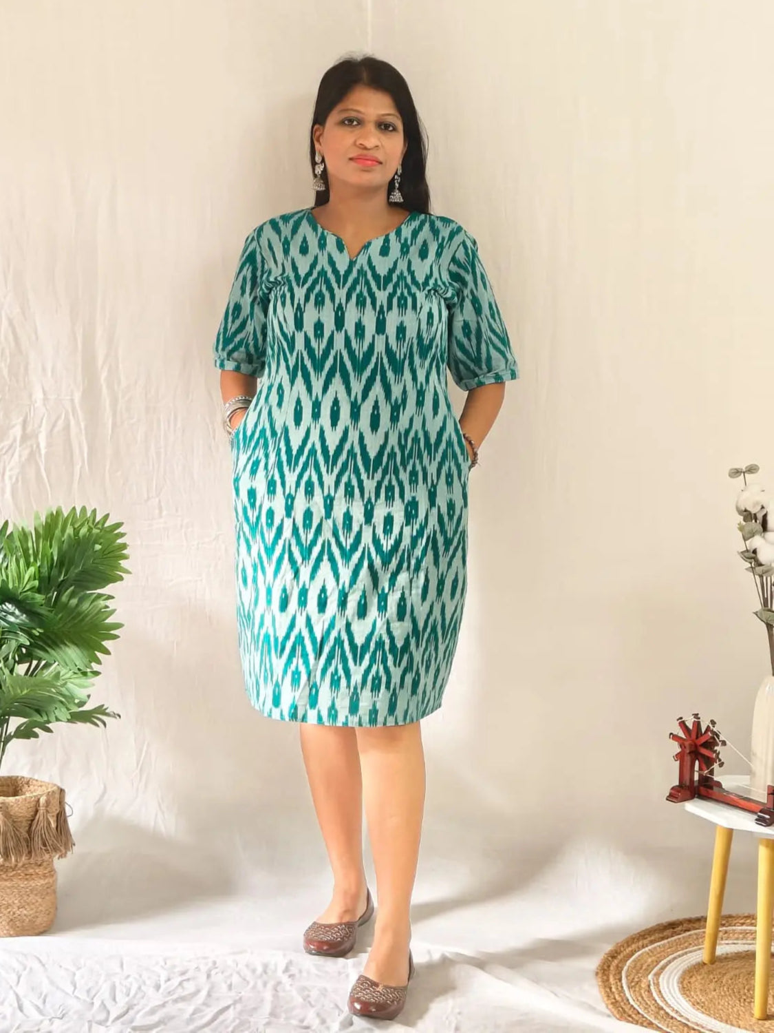 Front view of green ikkat shift dress styled in ethnic look with oxidised jewellery and jooti.