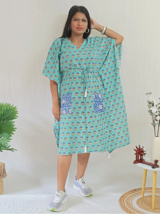 Front view of green block print kaftan with contrast pocket, styled with casual shoes.