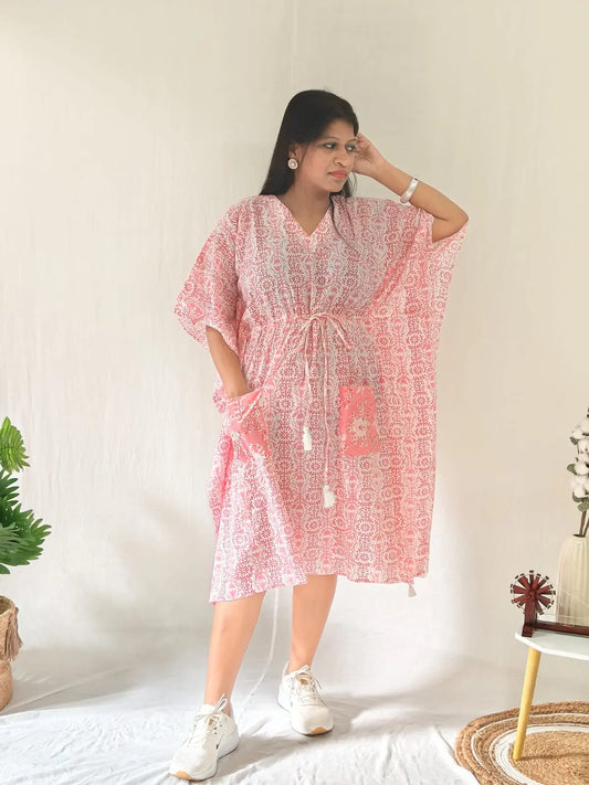 Front view of pink block print kaftan with contrast pocket, styled with casual shoes.