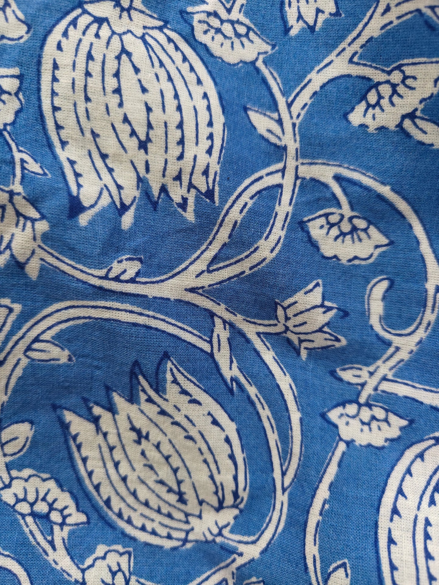 Zoom view showing block print detailing on blue kaftan fabric.