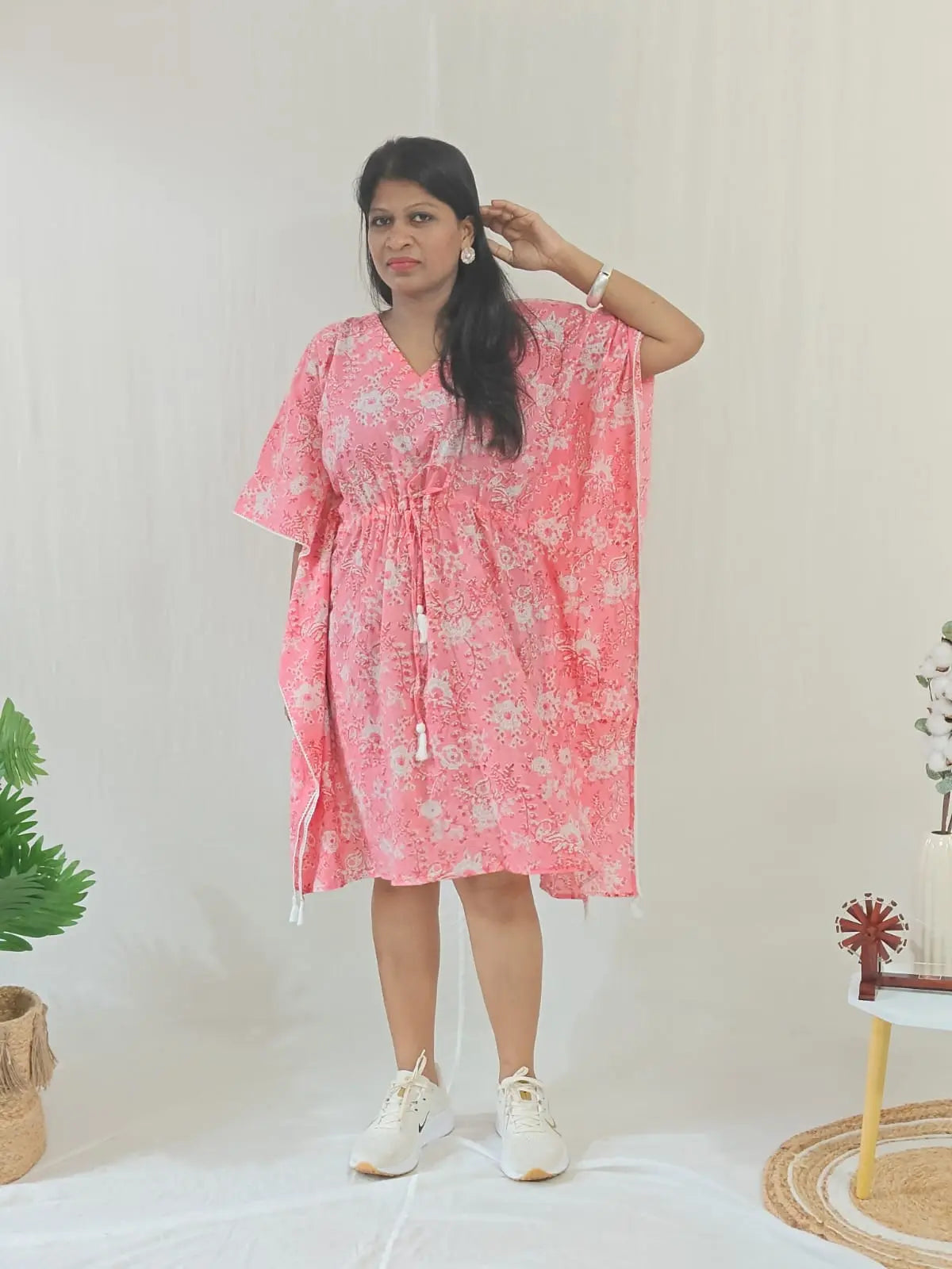 Front view of pink floral kaftan styled in a casual look.