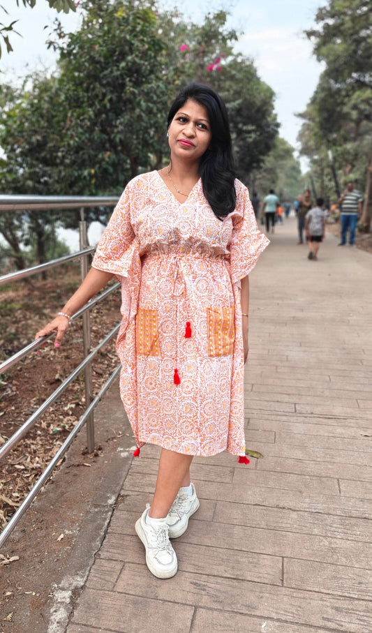 Front view of orange Sanganeri block print kaftan styled in a casual look.