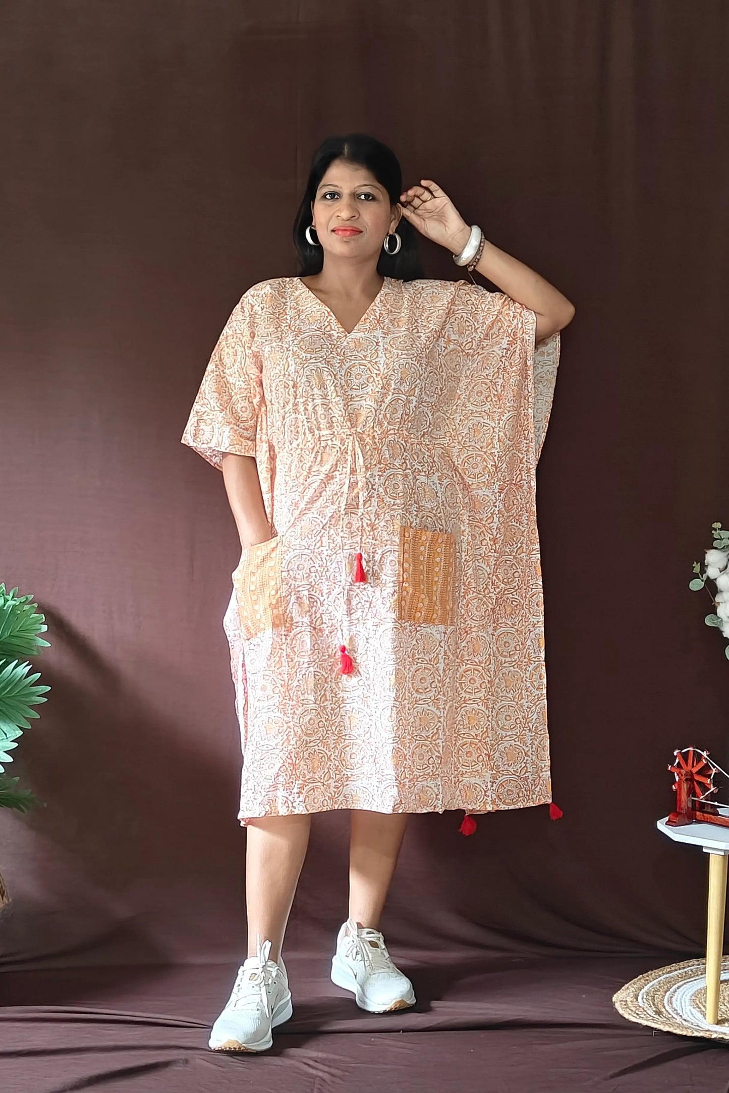 Front view of orange Sanganeri block print kaftan styled in a casual look.