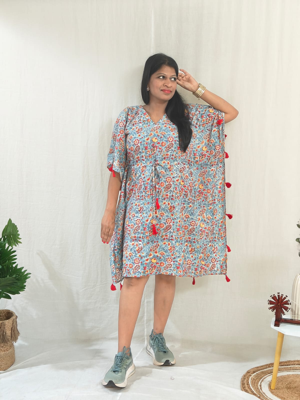 Front look of sea green kaftan featuring tassel accents, styled in a casual look.