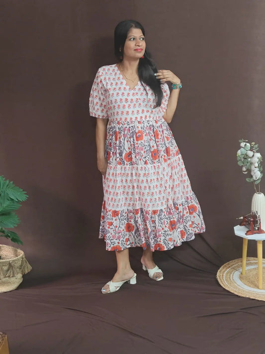 Model wearing Palasha White Dress in size XL – white tiered dress with orange artisan prints