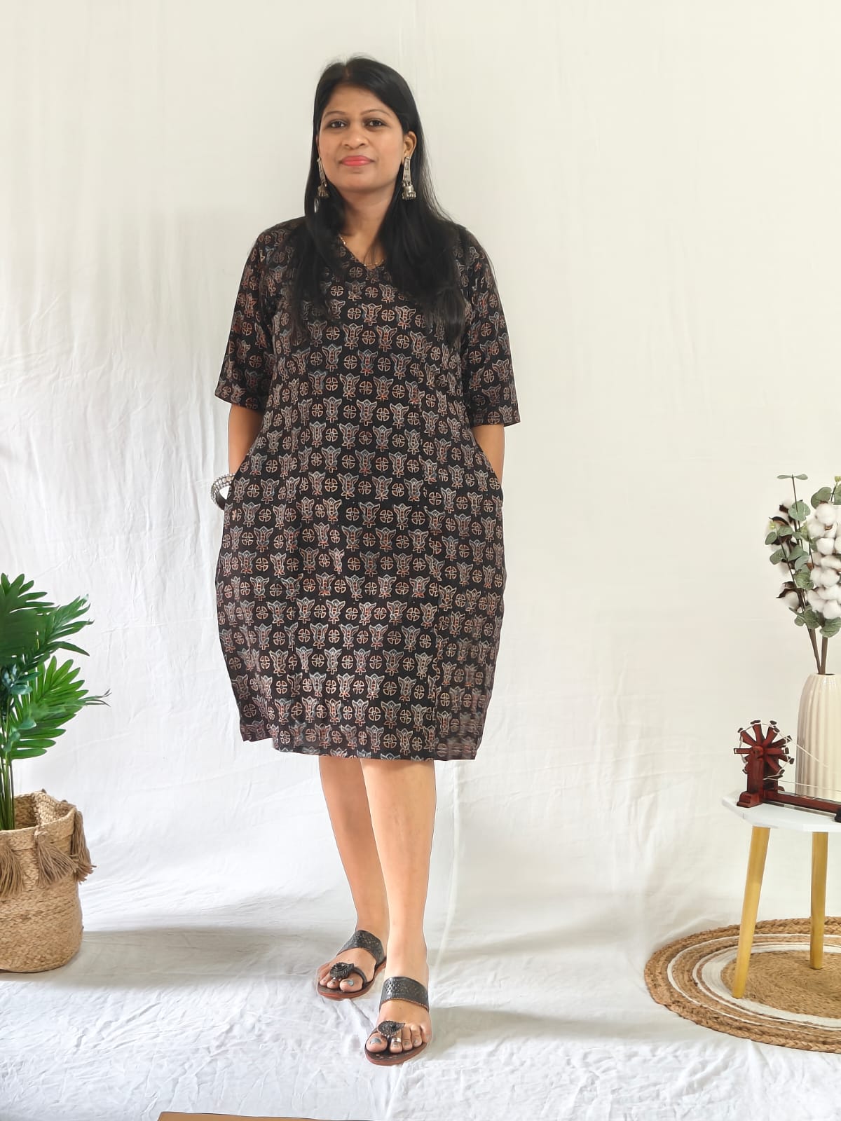 Front view: Black Ajrakh shift dress with pockets, oxidised jewellery, and toe-loop Indo-western flats.