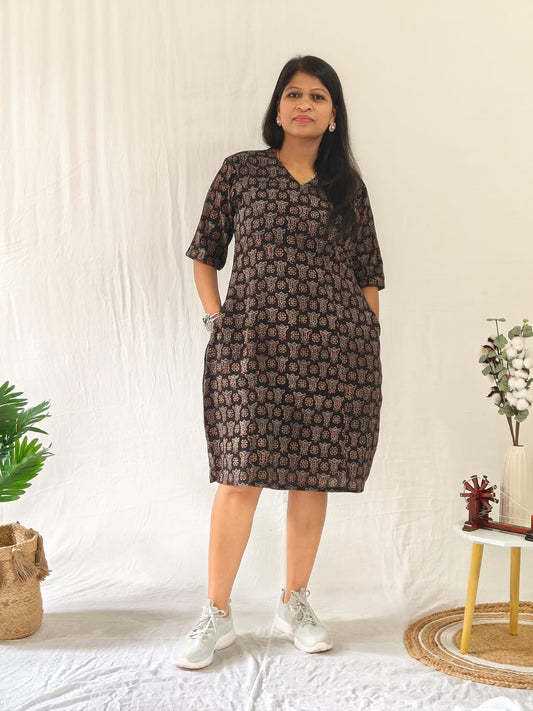 Front-facing model wearing a black Ajrakh block print shift dress with pockets, styled with casual shoes.