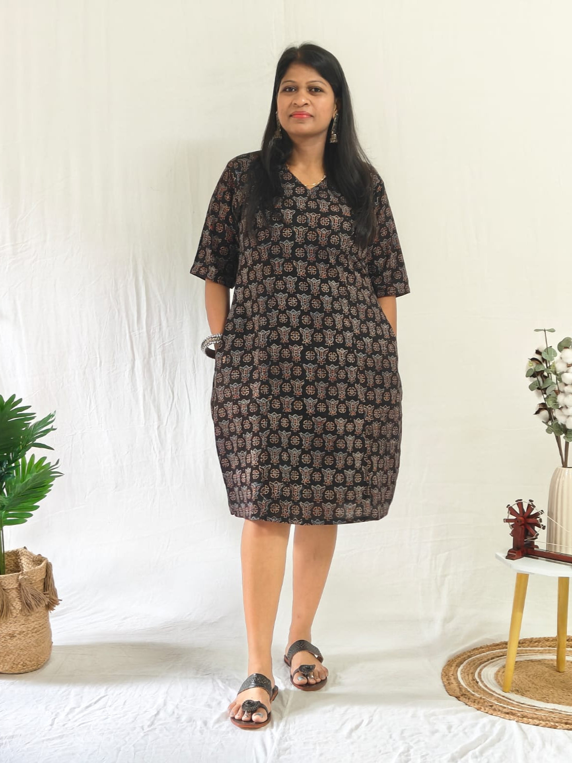 Front view: Black Ajrakh shift dress with pockets, oxidised jewellery, and toe-loop Indo-western flats.