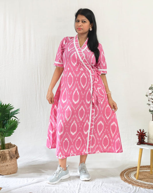 Front-facing model wearing a Pink Ikat cotton dress styled casually with white sneakers and silver jewellery.