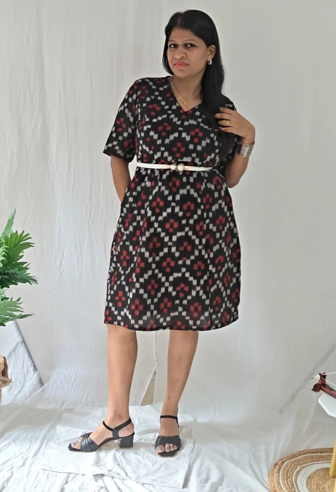 Front view Black ikkat dress with slim belt and sandal.
