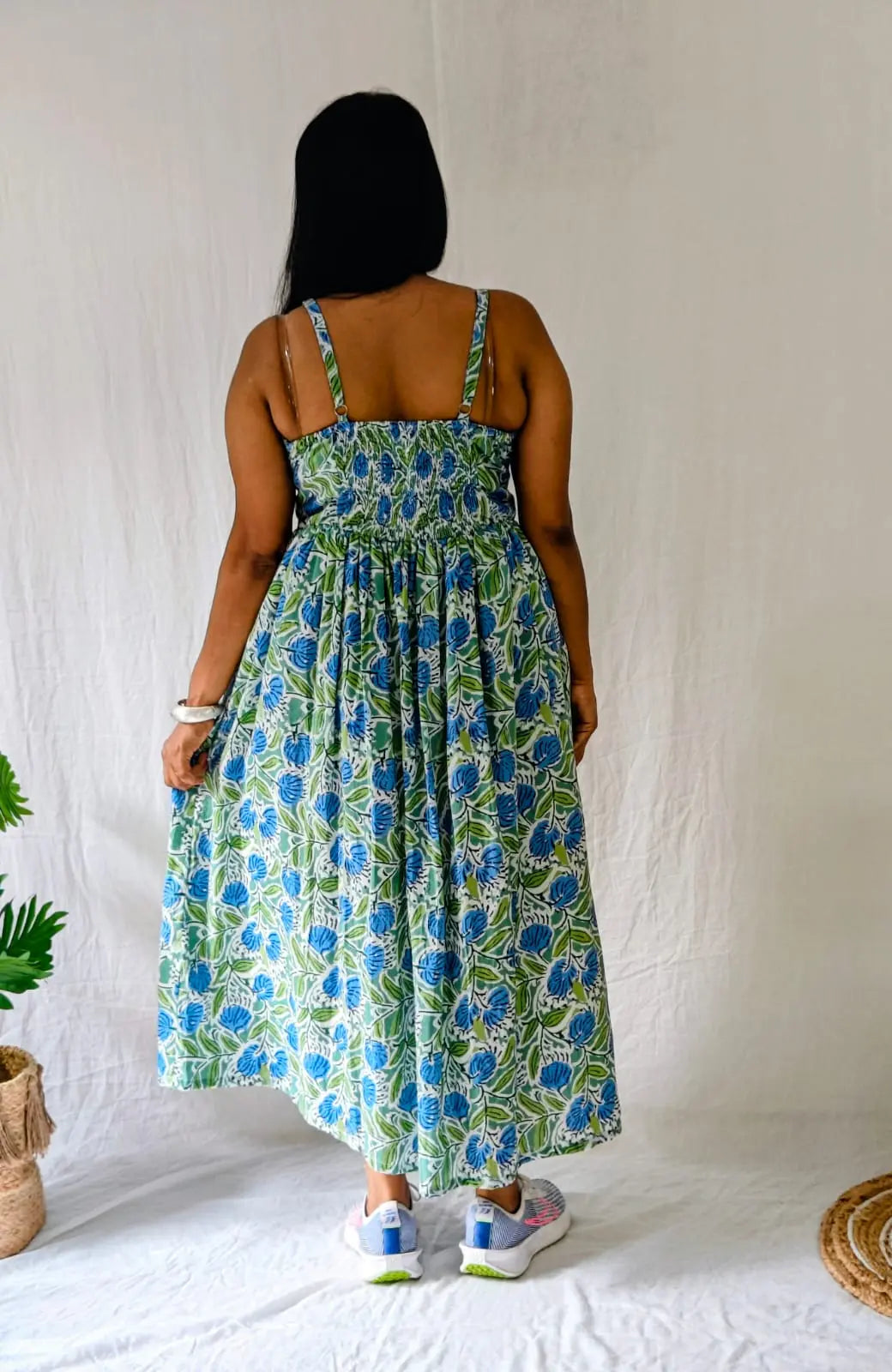 Back view of spaghetti strap floral dress with gathered waist and adjustable straps.