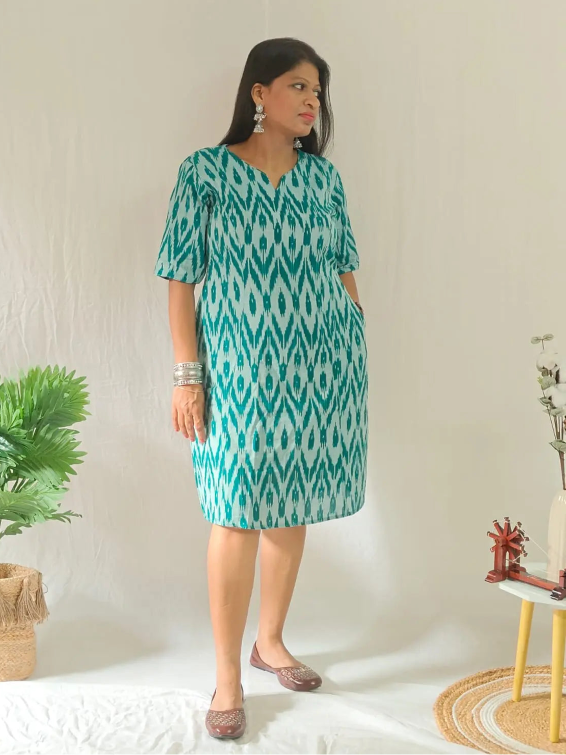 Front view of green ikkat shift dress styled in ethnic look with oxidised jewellery and jooti.