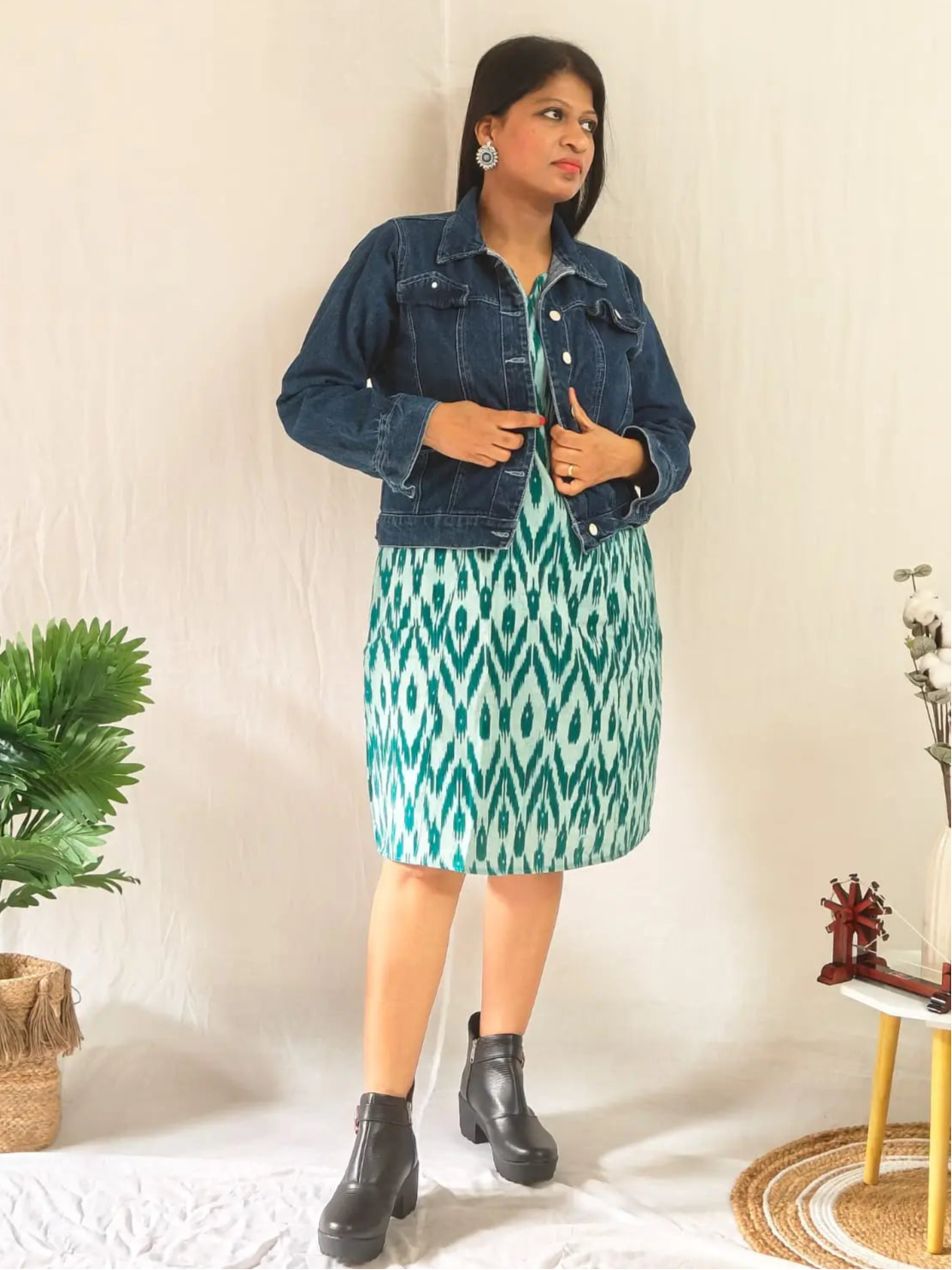 Front view of green ikkat shift dress layered with jacket and styled with ankle boots.