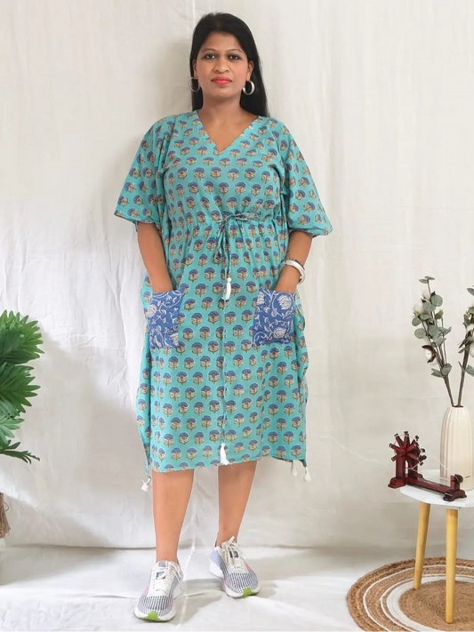 Front view of green block print kaftan with contrast pocket, styled with casual shoes.







