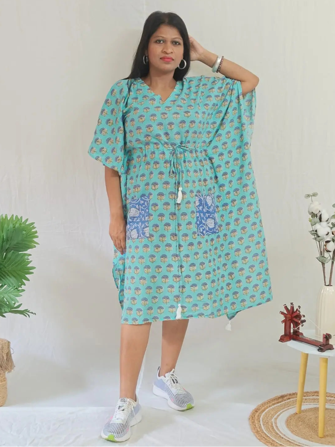Front view of green block print kaftan with contrast pocket, styled with casual shoes.







