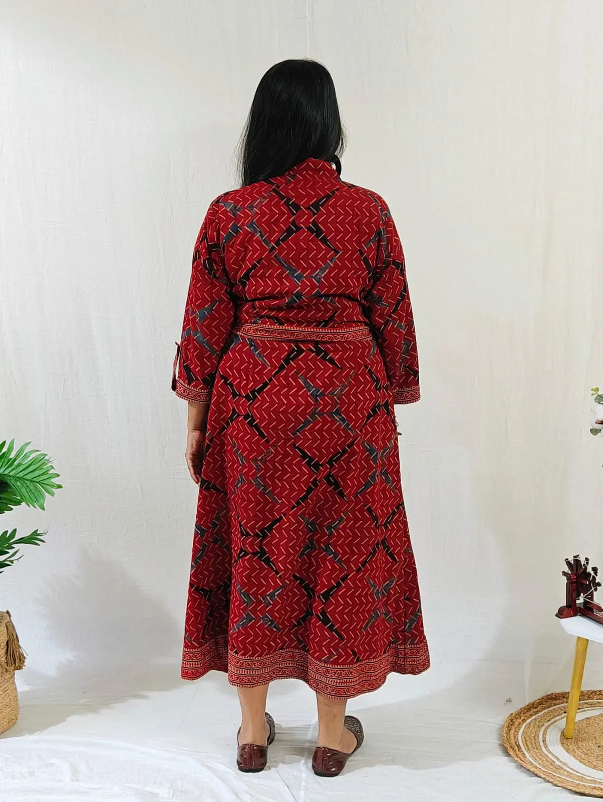 Back view of shirt dress with attached belt tied at the waist.