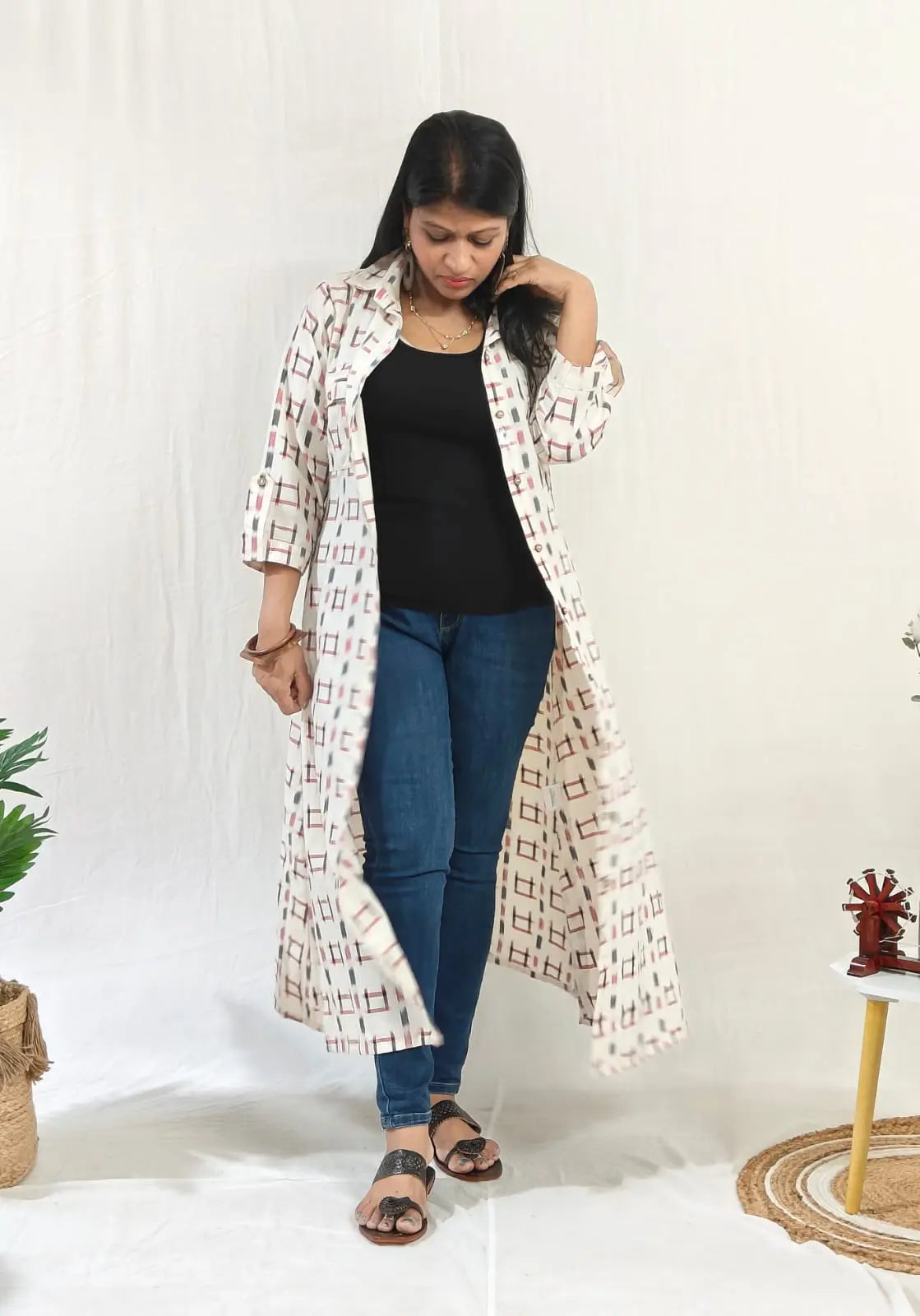 Front view of ikkat shift dress worn open with buttons over jeans for a casual layered look.
