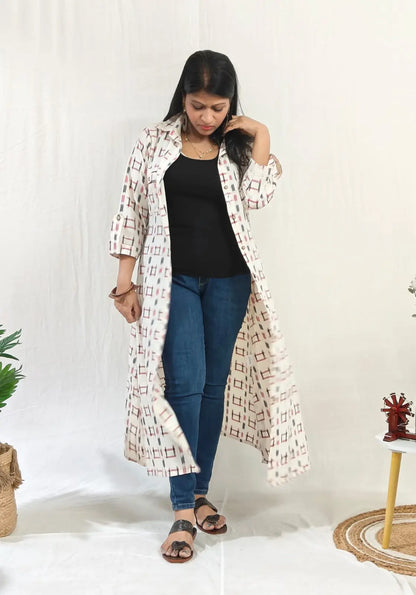 Front view of ikkat shift dress worn open with buttons over jeans for a casual layered look.