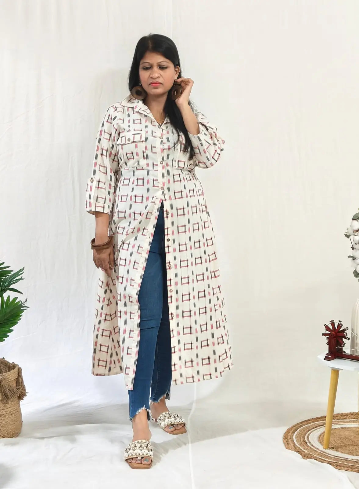 Front view of ikkat shift dress worn open with buttons over jeans for a casual layered look.