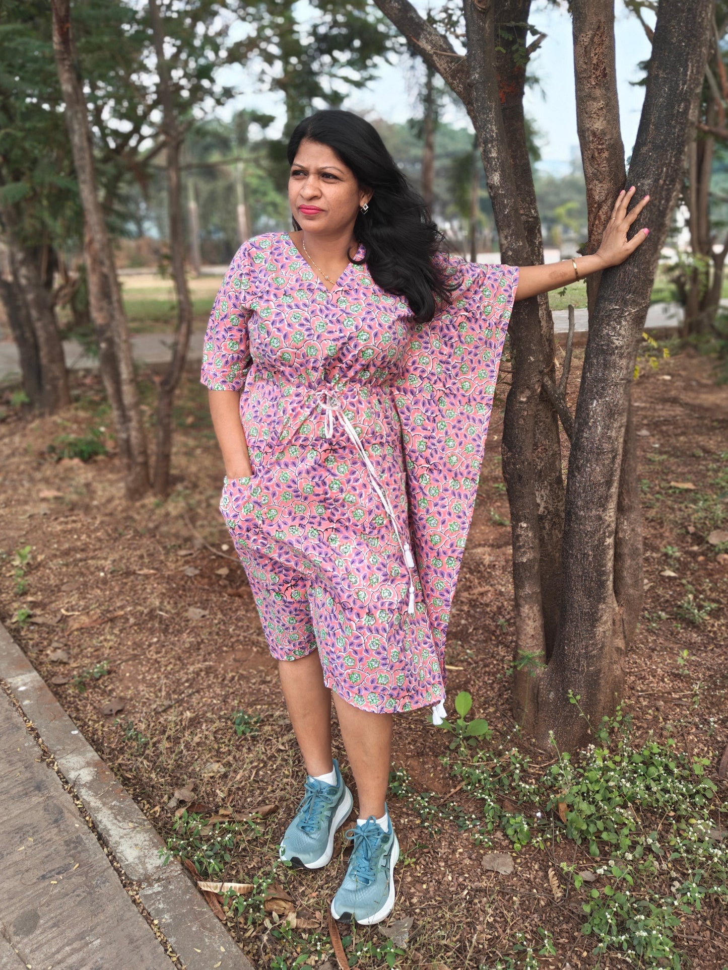 Front view of purple multi-print kaftan styled casually with flat shoes.