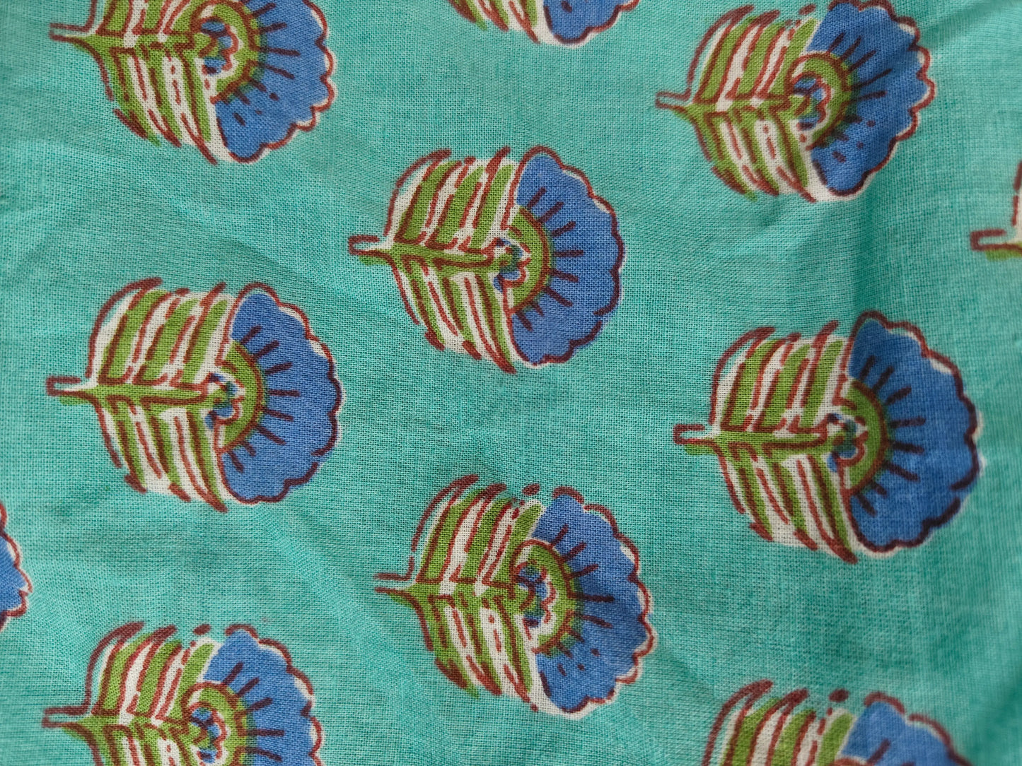 Zoom view showing green block print detailing on the kaftan fabric.