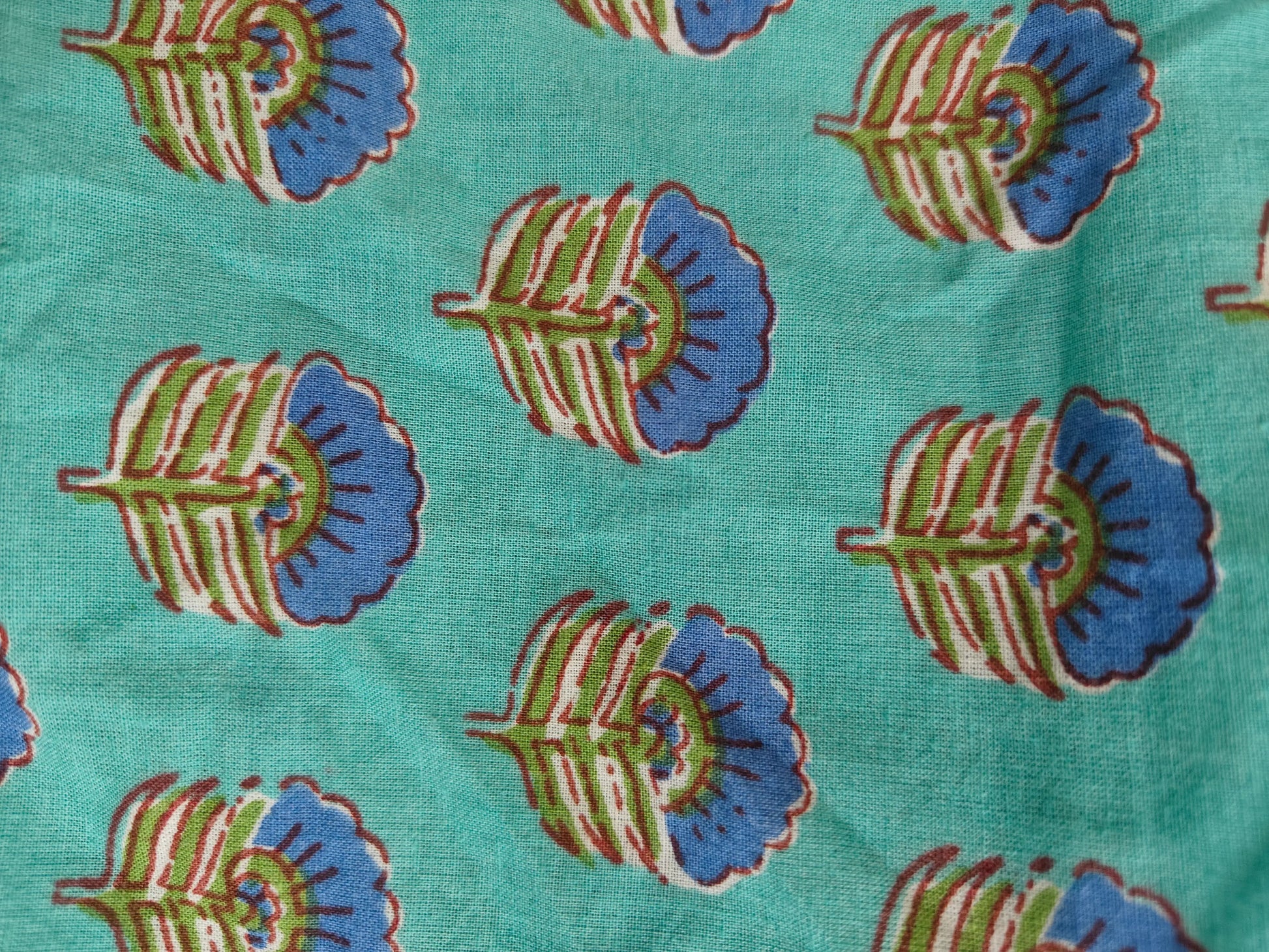 Zoom view showing green block print detailing on the kaftan fabric.