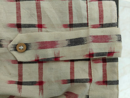 Zoom view of sleeve with decorative tab and button detail on cuff.