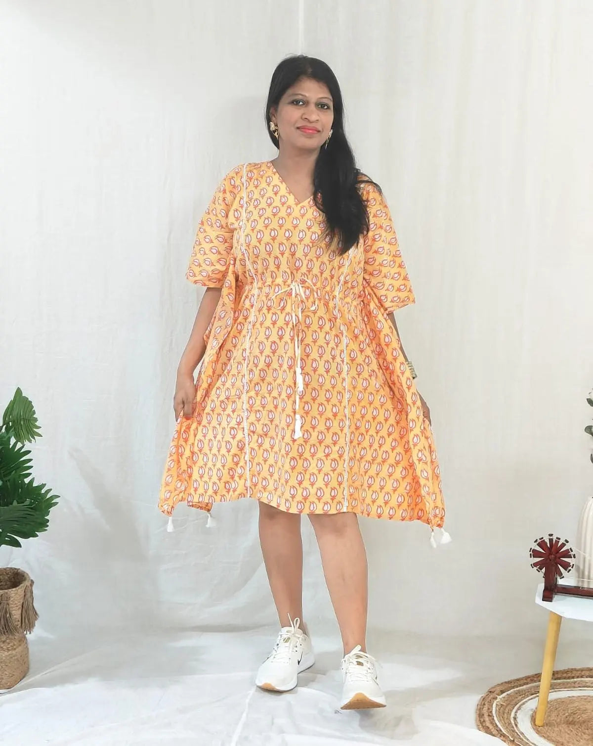 Front view of orange kaftan with casual shoes.