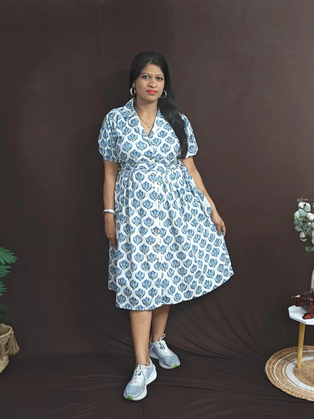 Front view of white cotton dress with blue blockprint, notched collar, and button-front opening