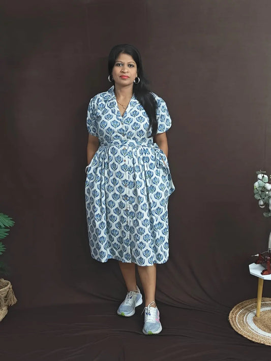White cotton dress with blue blockprint, notched collar, button opening, and pockets on both sides