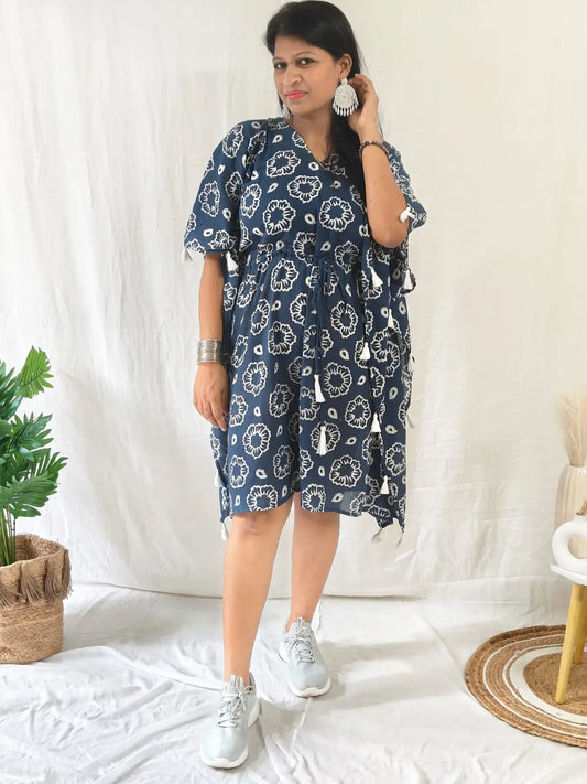 Front view of blue discharge block print kaftan with tassels on seam, styled casually with shoes.