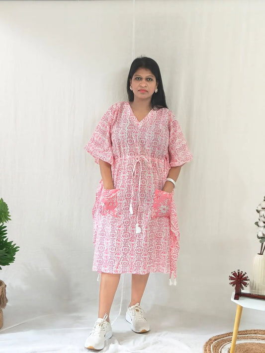 Front view of pink block print kaftan with contrast pocket, styled with casual shoes.