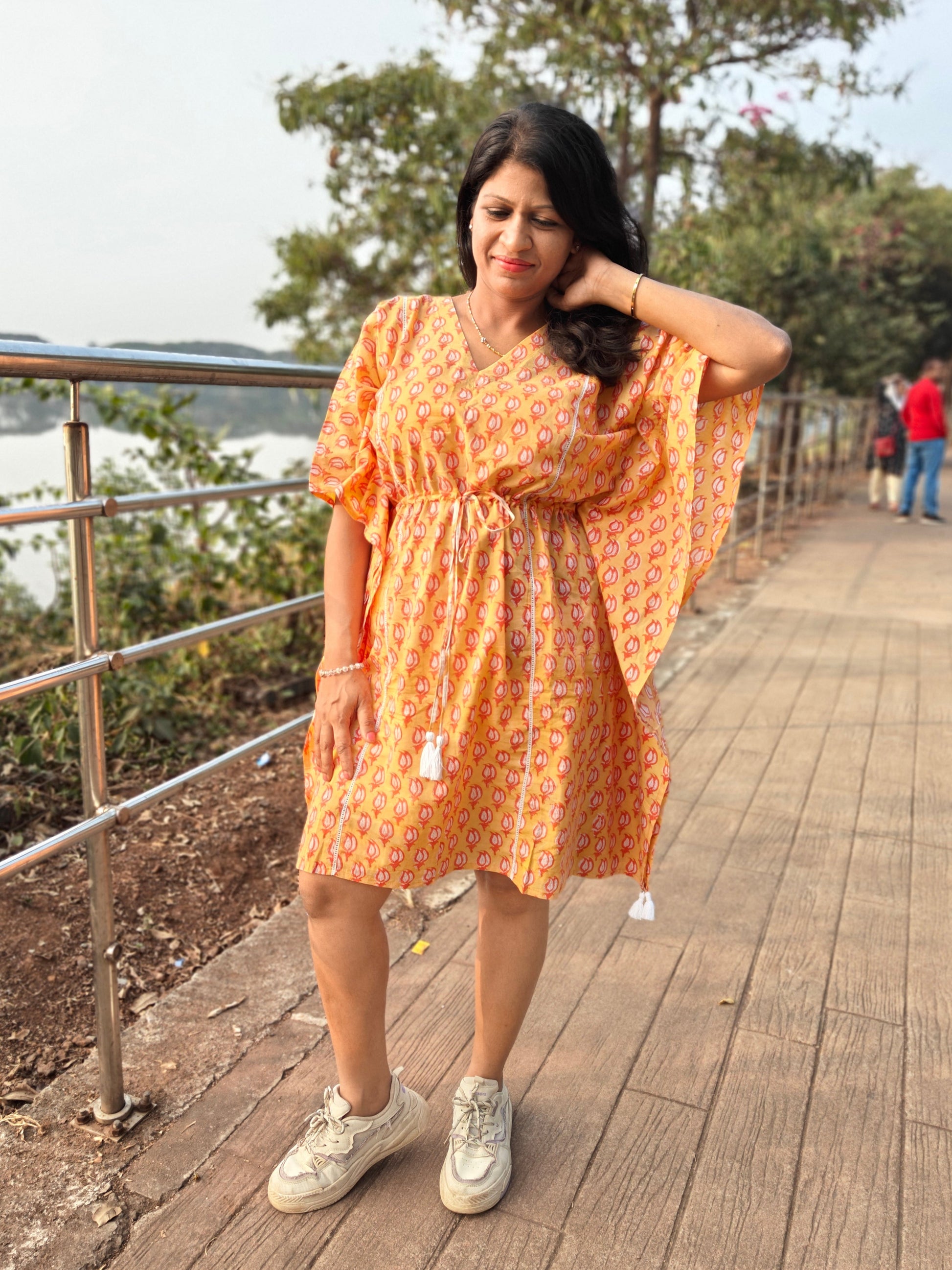 Front view of orange kaftan with casual shoes.