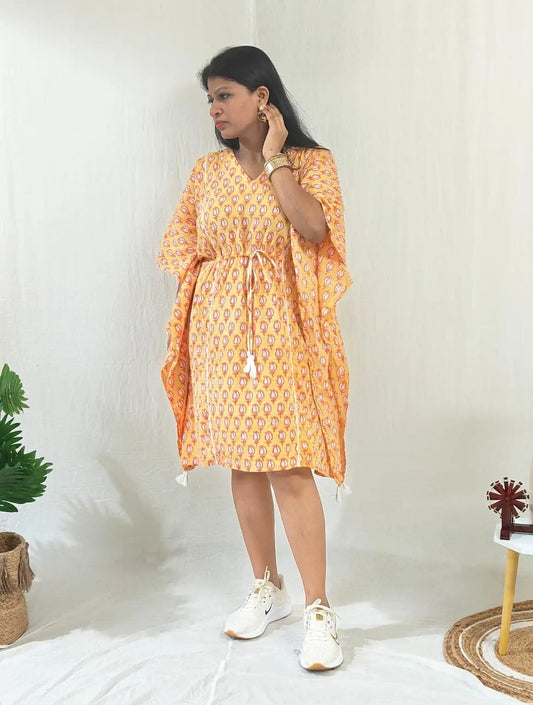 Front view of orange kaftan with casual shoes.