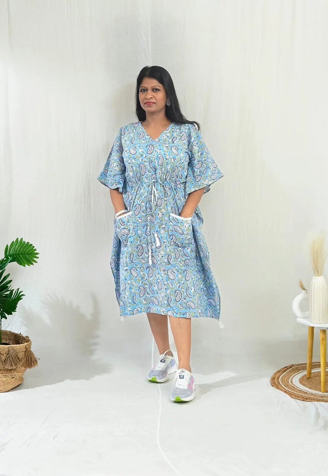 Casual front look: blue kaftan with sneakers and stud earrings.