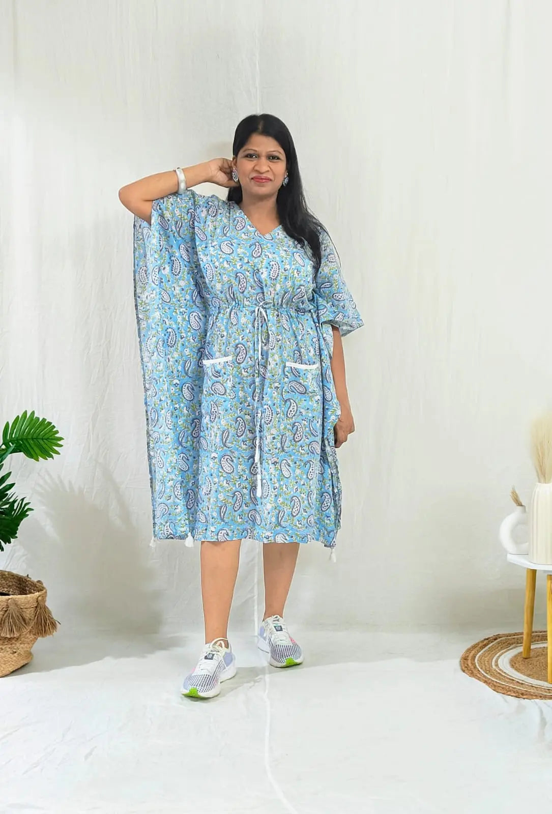 Casual front look: blue kaftan with sneakers and stud earrings.
