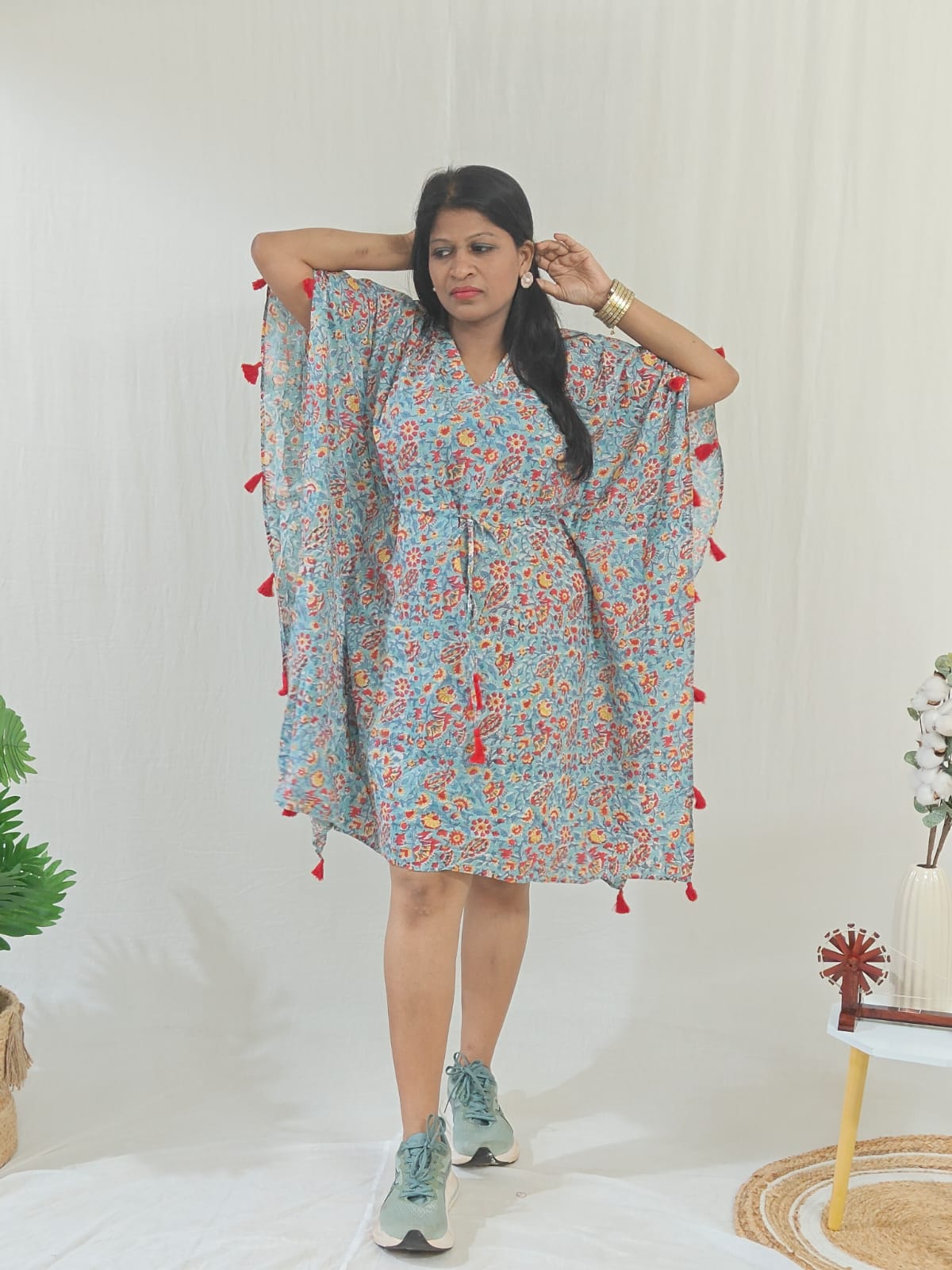 Front look of sea green kaftan featuring tassel accents, styled in a casual look.