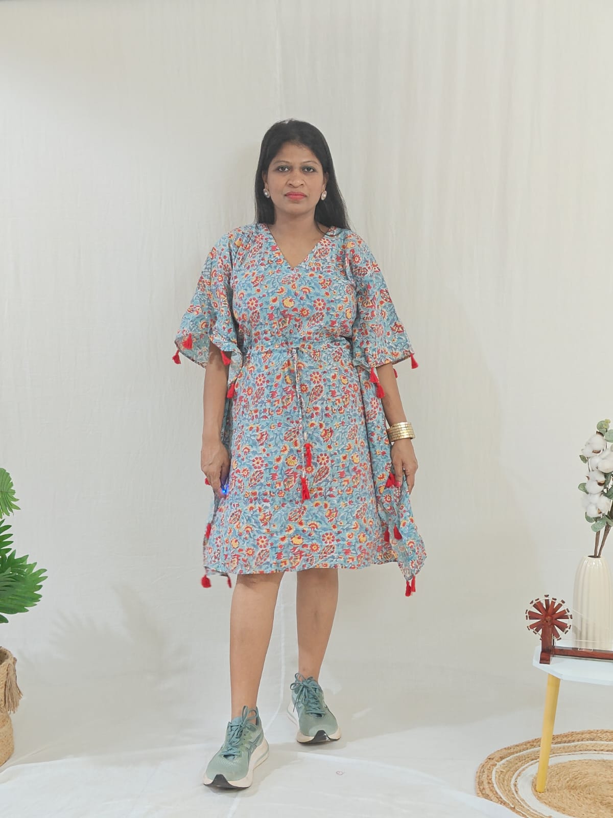 Front look of sea green kaftan featuring tassel accents, styled in a casual look.